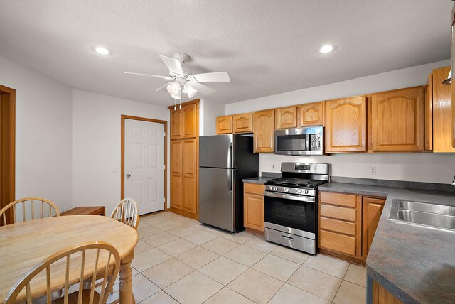 9479 Prairieview Trl N, Champlin, MN 55316 - kitchen featuring appliances with stainless steel finishes, a sink, dark countertops, a ceiling fan, and light tile patterned floors
