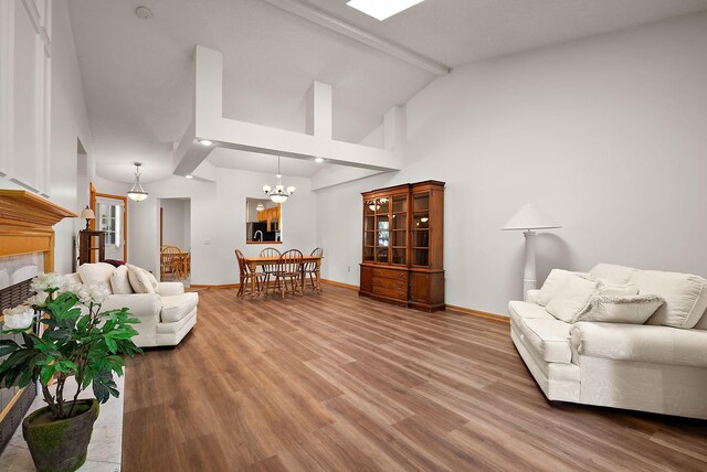 9479 Prairieview Trl N, Champlin, MN 55316 - living room featuring light wood-style floors, baseboards, a tile fireplace, a chandelier, and high vaulted ceiling