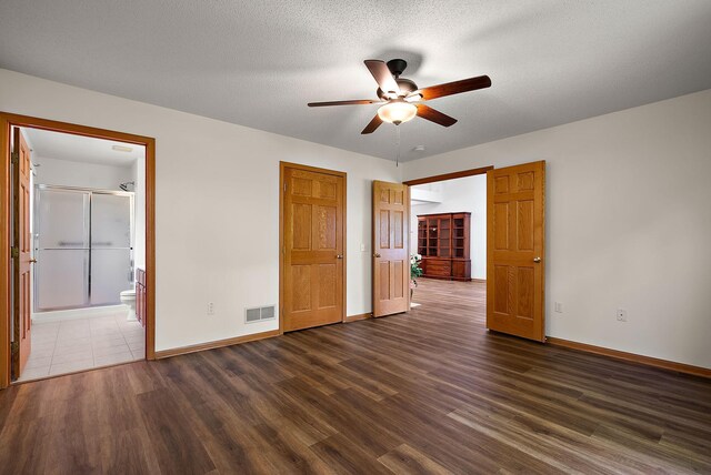 9479 Prairieview Trl N, Champlin, MN 55316 - unfurnished bedroom with dark wood-type flooring, baseboards, connected bathroom, and a ceiling fan