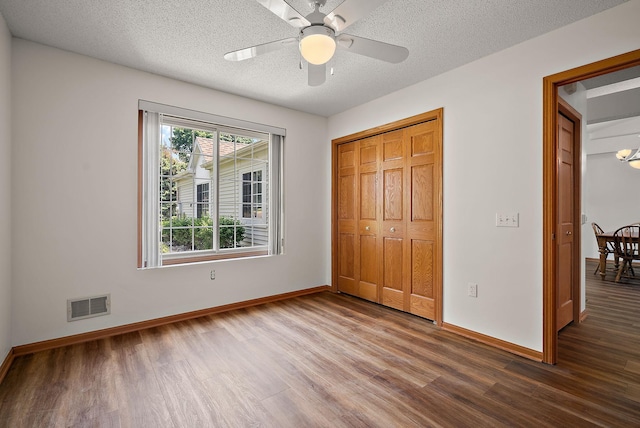 9479 Prairieview Trl N, Champlin, MN 55316 - unfurnished bedroom with wood finished floors, baseboards, a closet, and a textured ceiling