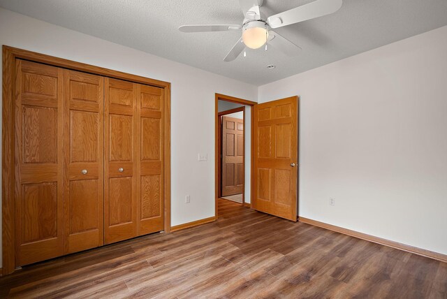 9479 Prairieview Trl N, Champlin, MN 55316 - unfurnished bedroom featuring wood finished floors, baseboards, ceiling fan, and a closet