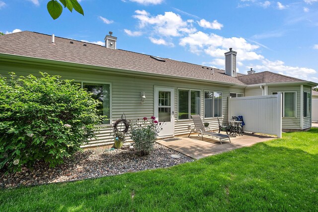 9479 Prairieview Trl N, Champlin, MN 55316 - rear view of house with a patio area, a yard, a chimney, and a shingled roof