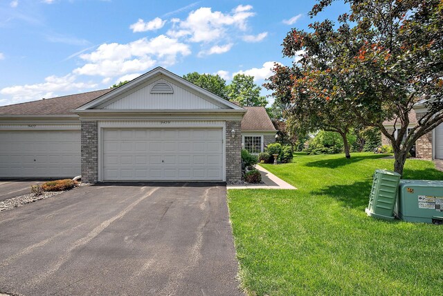 9479 Prairieview Trl N, Champlin, MN 55316 - view of front of property with asphalt driveway, a front yard, an attached garage, and brick siding