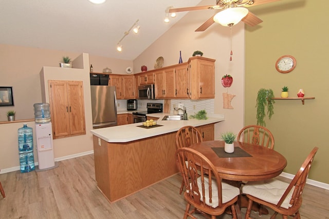 653 86th Ln NW, Coon Rapids, MN 55433 - kitchen featuring stainless steel appliances, a peninsula, backsplash, light countertops, and light wood-style flooring