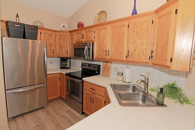 653 86th Ln NW, Coon Rapids, MN 55433 - kitchen featuring appliances with stainless steel finishes, light countertops, light wood-style floors, and backsplash