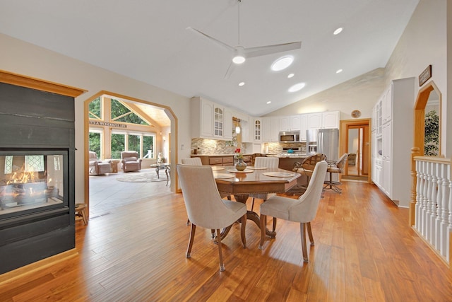 22946 185th St NW, Orrock Twp, MN 55309 - dining space featuring high vaulted ceiling, light wood-type flooring, a ceiling fan, recessed lighting, and a multi sided fireplace
