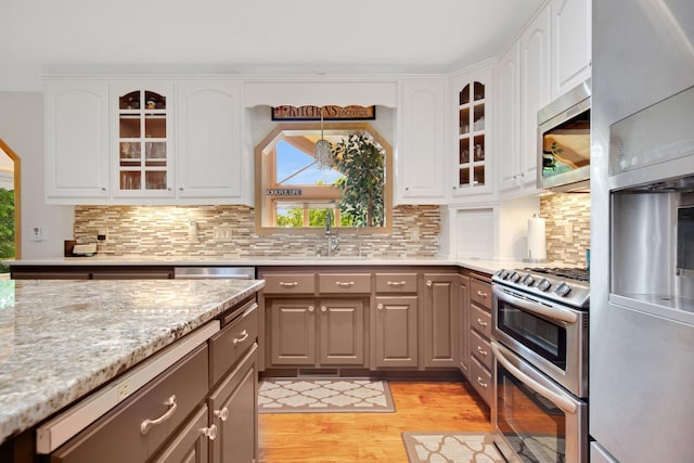 22946 185th St NW, Orrock Twp, MN 55309 - kitchen with stainless steel appliances, plenty of natural light, light wood finished floors, and glass insert cabinets