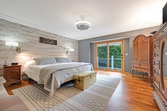 22946 185th St NW, Orrock Twp, MN 55309 - bedroom featuring access to exterior, wood walls, light wood-style flooring, and an accent wall