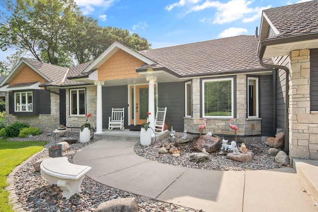 22946 185th St NW, Orrock Twp, MN 55309 - view of front facade featuring stone siding, covered porch, and roof with shingles