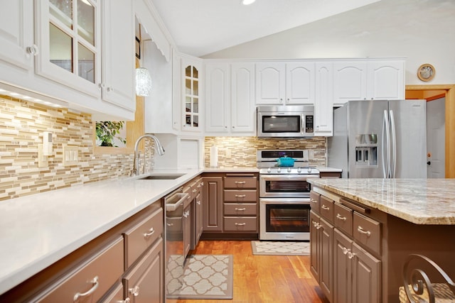 22946 185th St NW, Orrock Twp, MN 55309 - kitchen with stainless steel appliances, vaulted ceiling, light wood-style floors, white cabinets, and decorative backsplash