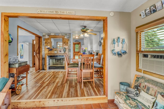 45909 Lands End Rd, Vergas, MN 56587 - dining area with a large fireplace, ceiling fan, a drop ceiling, and wood finished floors