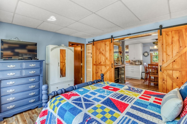 45909 Lands End Rd, Vergas, MN 56587 - bedroom featuring a barn door, wood finished floors, and a paneled ceiling