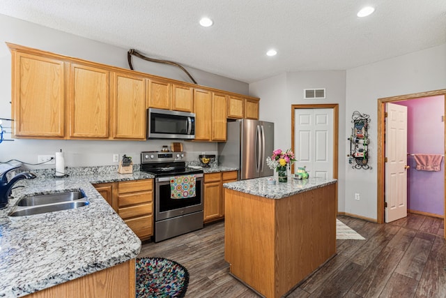 4505 Victor Path Unit 7, Hugo, MN 55038 - kitchen featuring appliances with stainless steel finishes, a sink, a textured ceiling, a kitchen island, and dark wood finished floors