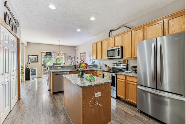 4505 Victor Path Unit 7, Hugo, MN 55038 - kitchen with stainless steel appliances, a peninsula, a textured ceiling, a center island, and recessed lighting