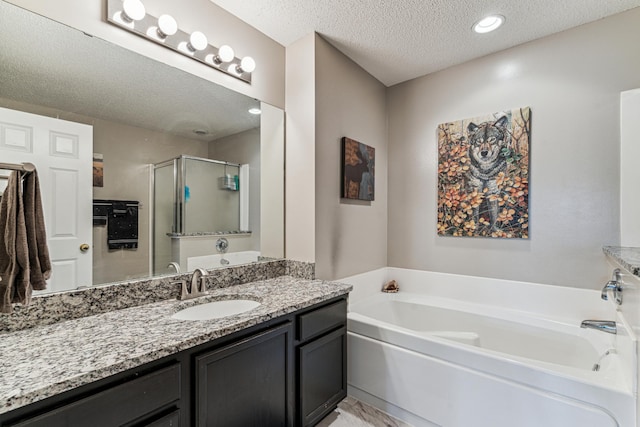 4505 Victor Path Unit 7, Hugo, MN 55038 - bathroom featuring a textured ceiling, a garden tub, vanity, and a shower stall