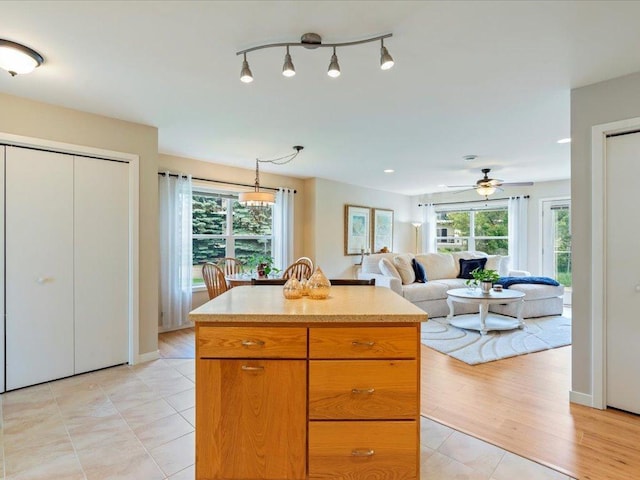 8025 Dalton Rd, Baxter, MN 56425 - kitchen featuring ceiling fan, light countertops, light tile patterned flooring, a kitchen island, and open floor plan