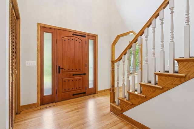 17575 Xenia St NW, Andover, MN 55304 - foyer entrance with stairway, light wood-style flooring, baseboards, and a towering ceiling