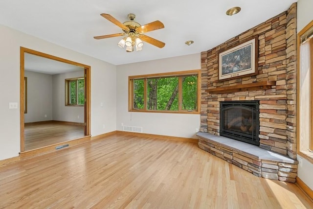 17575 Xenia St NW, Andover, MN 55304 - unfurnished living room featuring wood finished floors, a stone fireplace, a ceiling fan, and baseboards