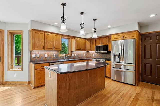 17575 Xenia St NW, Andover, MN 55304 - kitchen with appliances with stainless steel finishes, a sink, brown cabinetry, dark countertops, and recessed lighting