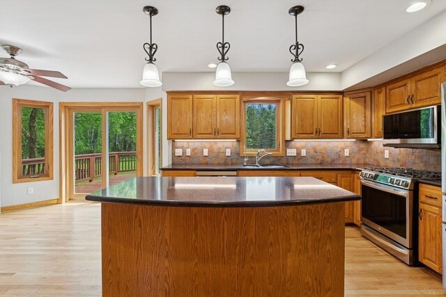 17575 Xenia St NW, Andover, MN 55304 - kitchen featuring stainless steel range with gas cooktop, a sink, brown cabinets, a center island, and tasteful backsplash