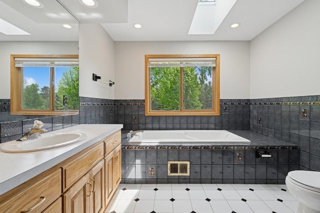 17575 Xenia St NW, Andover, MN 55304 - bathroom with a skylight, toilet, vanity, a bath, and tile patterned floors