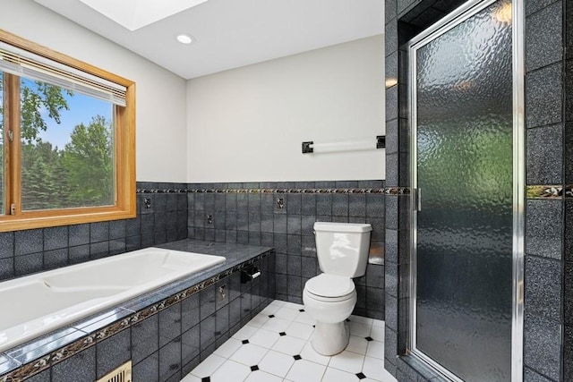 17575 Xenia St NW, Andover, MN 55304 - bathroom with toilet, a skylight, tile walls, a shower stall, and tile patterned flooring