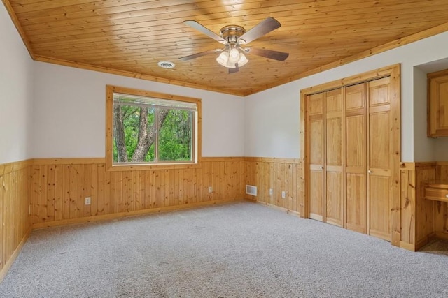 17575 Xenia St NW, Andover, MN 55304 - unfurnished bedroom with a wainscoted wall, wood ceiling, wood walls, a closet, and carpet