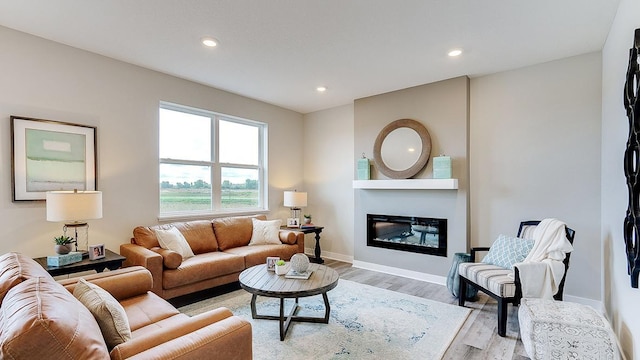 6573 209th St W, Farmington, MN 55024 - living room featuring light wood finished floors, a glass covered fireplace, recessed lighting, and baseboards