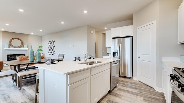 6573 209th St W, Farmington, MN 55024 - kitchen featuring appliances with stainless steel finishes, a sink, light wood-style floors, light countertops, and white cabinetry