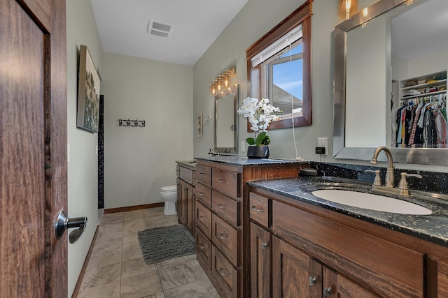 944 Cove Ct NW, Sauk Rapids, MN 56379 - full bath with double vanity, toilet, baseboards, a spacious closet, and marble look tile flooring