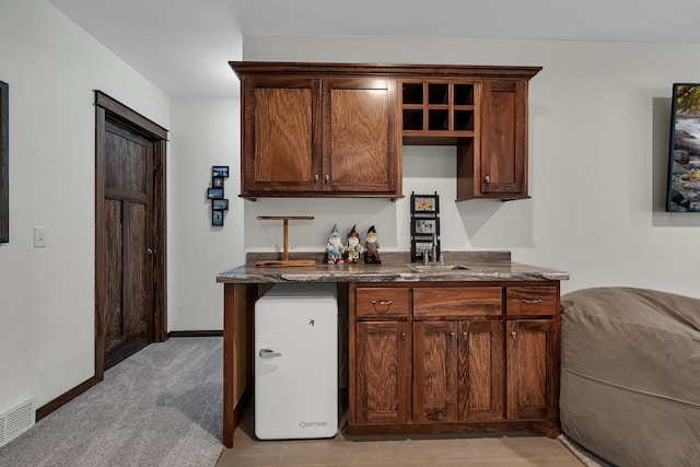 944 Cove Ct NW, Sauk Rapids, MN 56379 - kitchen featuring dark stone counters, baseboards, and refrigerator