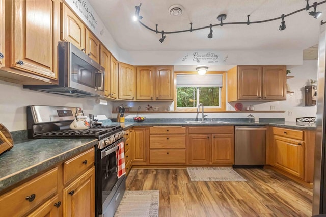32157 County Road 39, Breezy Point, MN 56472 - kitchen with stainless steel appliances, dark countertops, wood finished floors, and track lighting