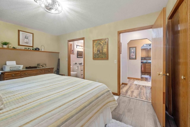 32157 County Road 39, Breezy Point, MN 56472 - bedroom with light wood-style flooring, a textured ceiling, ensuite bathroom, and arched walkways