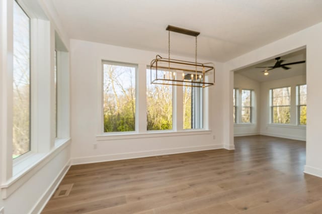 19908 67th Ave, Corcoran, MN 55340 - unfurnished dining area featuring a chandelier, healthy amount of natural light, and wood finished floors