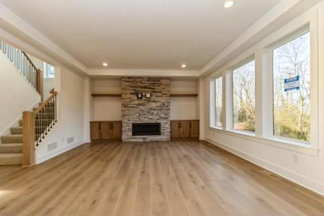 19908 67th Ave, Corcoran, MN 55340 - unfurnished living room featuring plenty of natural light, light wood-style floors, baseboards, a fireplace, and recessed lighting
