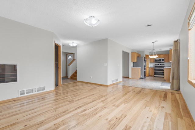 2909 Molina St, Shakopee, MN 55379 - unfurnished living room featuring light wood-style flooring, stairway, and baseboards