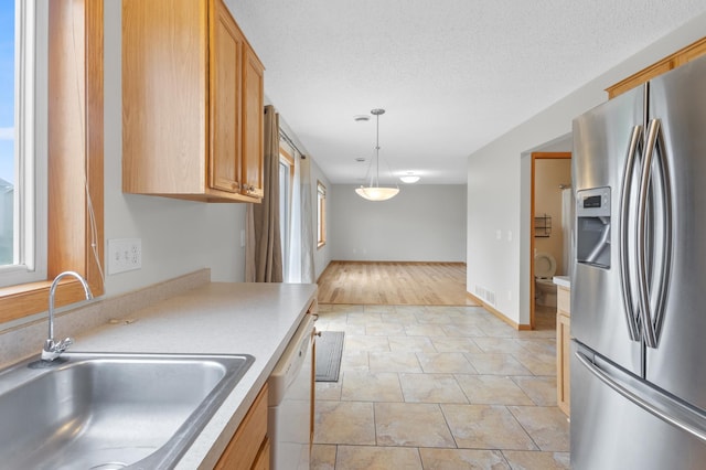 2909 Molina St, Shakopee, MN 55379 - kitchen featuring stainless steel refrigerator with ice dispenser, white dishwasher, pendant lighting, light countertops, and plenty of natural light