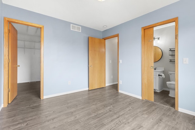 2909 Molina St, Shakopee, MN 55379 - unfurnished bedroom with wood finished floors, a walk in closet, a closet, and connected bathroom