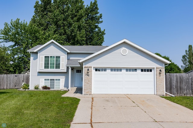 715 49th St S, Fargo, ND 58103 - split level home with concrete driveway, an attached garage, and brick siding