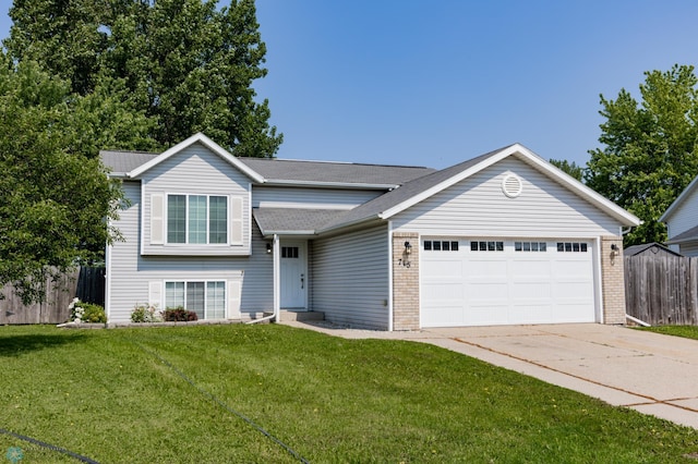715 49th St S, Fargo, ND 58103 - tri-level home with an attached garage, driveway, brick siding, and roof with shingles