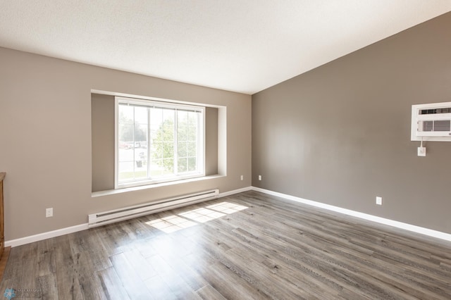 715 49th St S, Fargo, ND 58103 - spare room featuring baseboard heating, wood finished floors, baseboards, and an AC wall unit