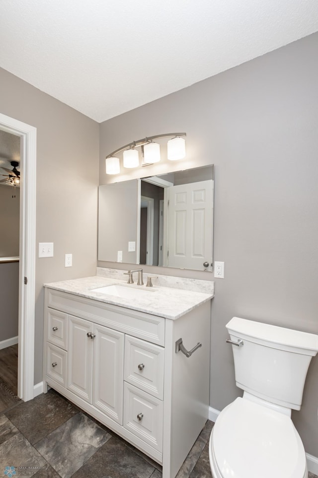 715 49th St S, Fargo, ND 58103 - bathroom with vanity, baseboards, toilet, and a ceiling fan