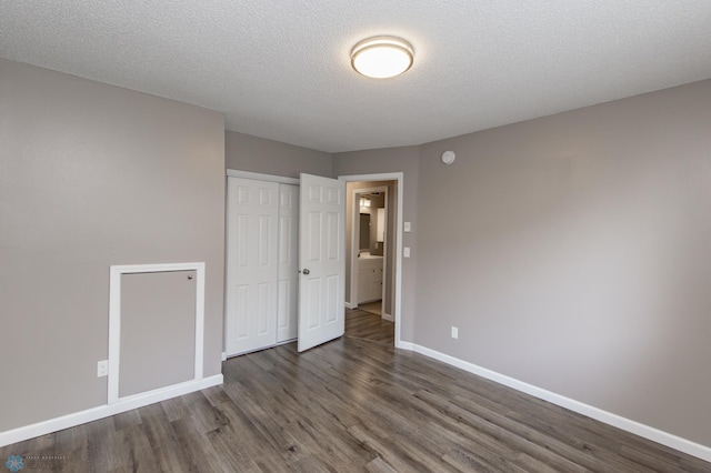 715 49th St S, Fargo, ND 58103 - unfurnished bedroom featuring baseboards, wood finished floors, a closet, and a textured ceiling
