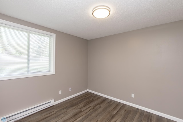 715 49th St S, Fargo, ND 58103 - spare room with a baseboard heating unit, dark wood-type flooring, baseboards, and a textured ceiling