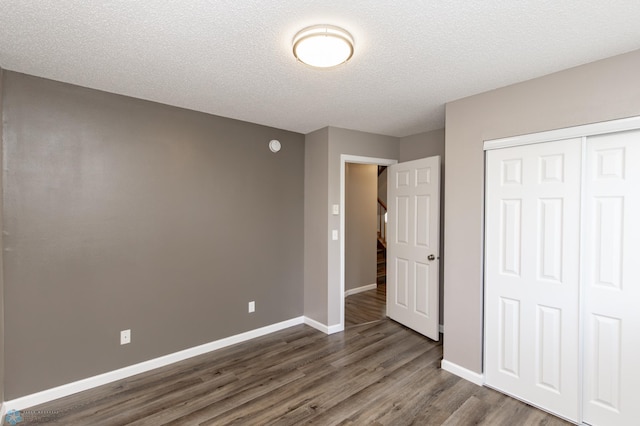715 49th St S, Fargo, ND 58103 - unfurnished bedroom with dark wood-style flooring, a closet, baseboards, and a textured ceiling