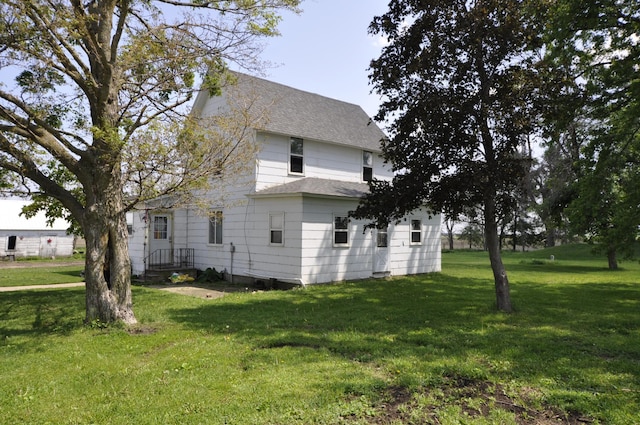 69198 235th St, Dexter, MN 55926 - view of property exterior featuring roof with shingles and a lawn
