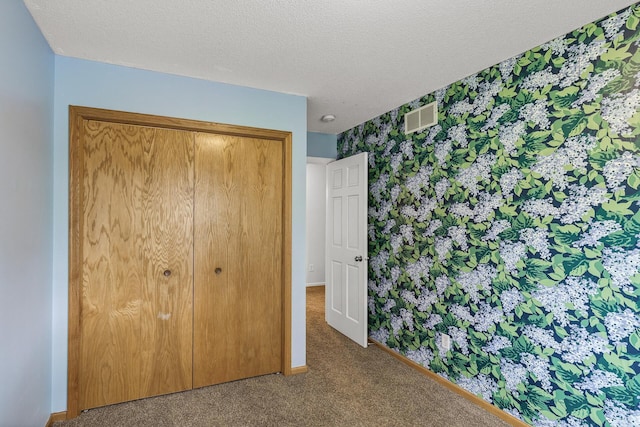 6956 Delarosa Ct, Inver Grove Heights, MN 55076 - unfurnished bedroom featuring carpet floors, a closet, a textured ceiling, and wallpapered walls