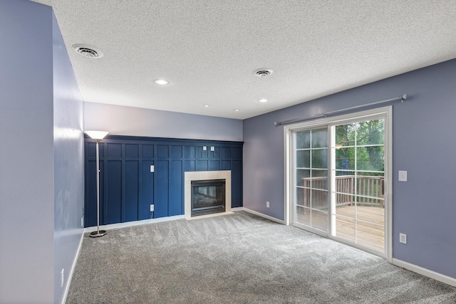 6956 Delarosa Ct, Inver Grove Heights, MN 55076 - unfurnished living room with carpet flooring, a tiled fireplace, and a textured ceiling
