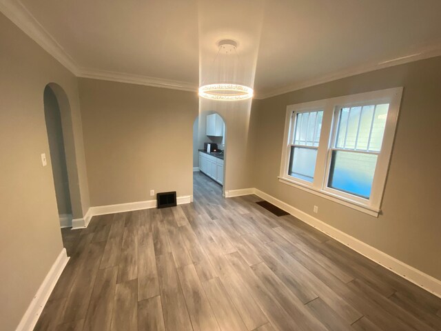 1138 6th Ave SE, Rochester, MN 55904 - unfurnished room featuring arched walkways, ornamental molding, and dark wood finished floors