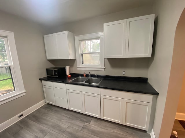 1138 6th Ave SE, Rochester, MN 55904 - kitchen with stainless steel microwave, dark countertops, white cabinets, and arched walkways